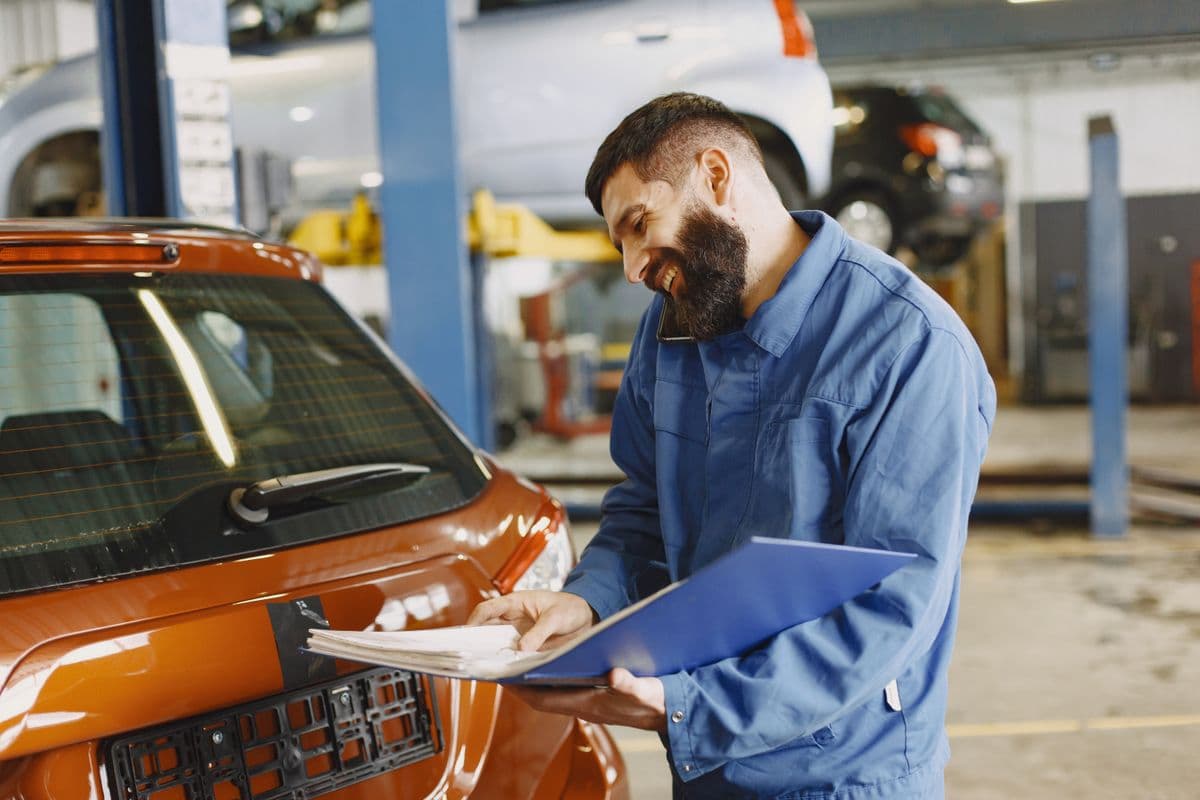 A mechanic inspecting a vehicle on the hoist before sale